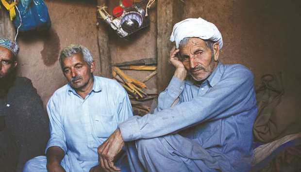Chaudhry Hakam Deen (second right) sits with relatives in their bunker next to their house in Dhanna village, near the Line of Control (LoC) in Pakistan-administered Kashmir during a cross-border shelling by Indian troops.