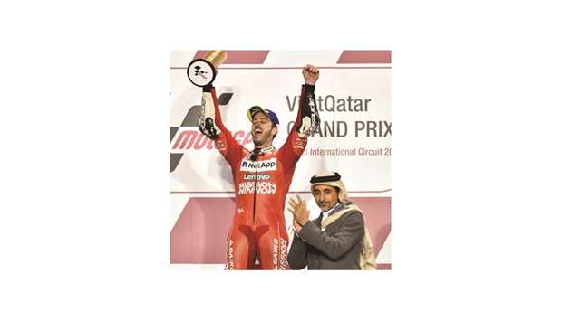 MotoGP winner Andrea Dovizioso of Italy exults after receiving his trophy from HE the Minister of Culture and Sports Salah bin Ghanem bin Nasser al-Ali at the Losail International Circuit yesterday. PICTURES: Noushad Thekkayil and agencies