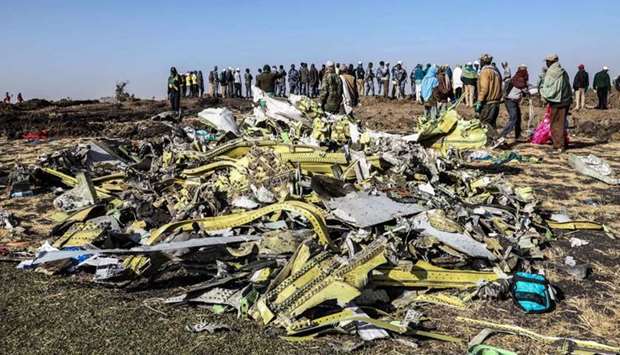 People stand near collected debris at the crash site of Ethiopia Airlines near Bishoftu