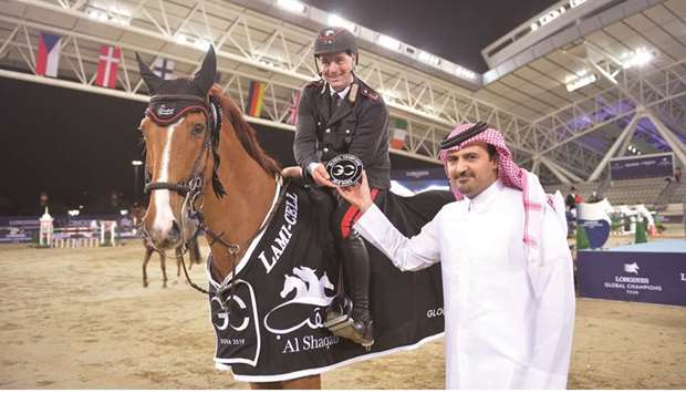 Emanuele Gaudiano of Italy receives his prize from Khalifa al-Attiyah, Executive Director of Al Shaqab after winning the feature class at the Global Champions Tour yesterday.