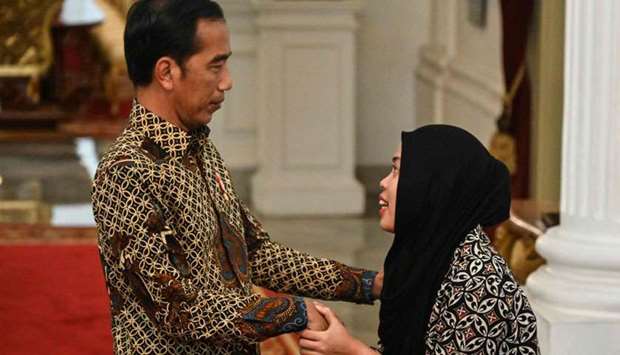 Indonesia's President Joko Widodo (L) welcomes Siti Aisyah (R) during their meeting at palace in Jakarta