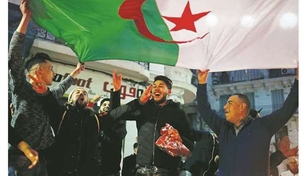 People celebrate on the streets after President Abdelaziz Bouteflika announced he will not run for a fifth term, in Algiers, yesterday.