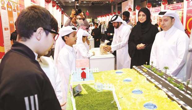 HE al-Hammadi being briefed on a studentu2019s project at the exhibition.