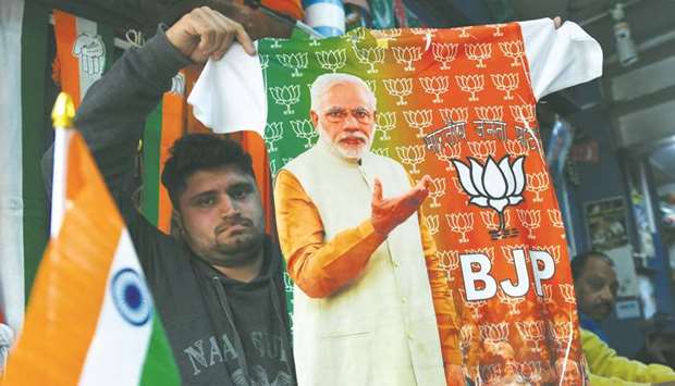 A shopkeeper sells a T-shirt bearing the picture of Prime Minister Narendra Modi at a shop in New Delhi yesterday. India is not just the worldu2019s biggest democracy, its elections are also the most gruelling u2013 with nearly six weeks between the first round of voting on April 11 and the last.