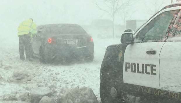 A policeman talks to a driver as snow clogs the roads in Lone Tree, Colorado, on Wednesday.