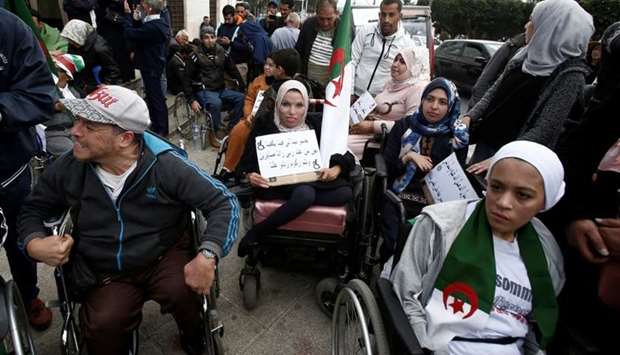 People with special needs, accompanied by their families, take part in a protest demanding immediate political change and improvement of their living conditions in Algiers