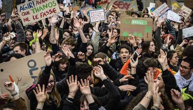Protesters hold placards during a demonstration as part of a global day of student protests aiming to push world leaders into action on climate change on March 15, 2019, in Valence, southeastern France