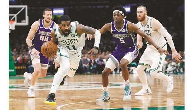 Boston Celtics guard Kyrie Irving (second left) drives to the basket past Sacramento Kings point guard Deu2019Aaron Fox during the NBA game. (USA TODAY Sports)