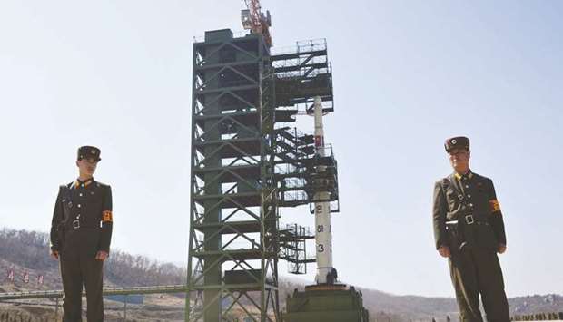 This file photo taken on April 8, 2012 shows two North Korean soldiers standing guard in front of the Unha-3 rocket at at the Sohae Satellite Launch Station in Tongchang-Ri. Activity has been detected at a North Korean long-range rocket site suggesting Pyongyang may be pursuing the u201crapid rebuildingu201d of a test facility after the collapse of the Hanoi summit.