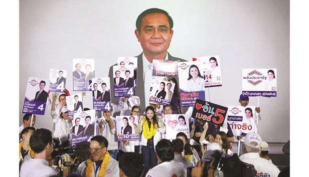 Supporters and candidates celebrate in front of a picture showing Thailandu2019s Prime Minister Prayut Chan-o-cha during the Palang Pracharat Party campaign rally in Bangkok yesterday.