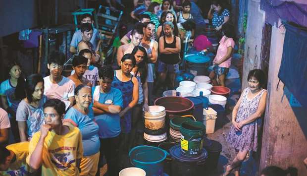 Residents of Addition Hills in Mandaluyong City, Manila, queue to receive water distributed on water tank trucks and fire trucks, yesterday.