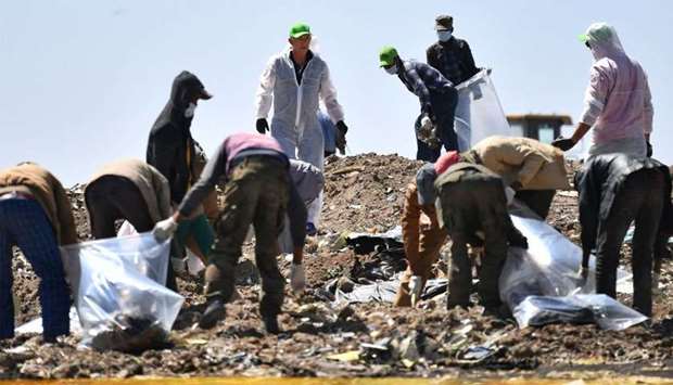 People work to search for belongings and debris for forensic analysis at the crash site of the Ethiopian Airlines operated Boeing 737 MAX aircraft in which their relatives perished among the 157 passengers and crew onboard, at Hama Quntushele village