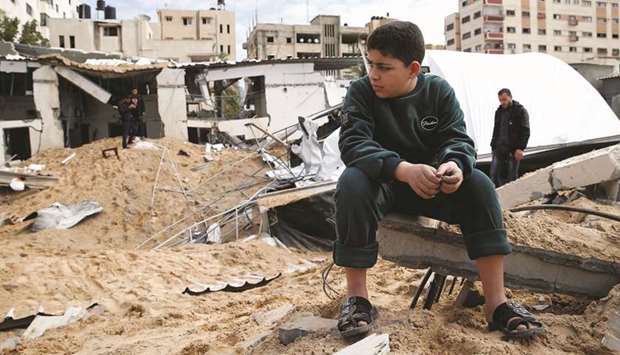 A Palestinian boy sits next to the destroyed Hamas site following Israeli air strikes, in Gaza City, yesterday.