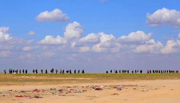 Civilians walk together near Baghouz, Deir Al Zor province, Syria, March 6, 2019