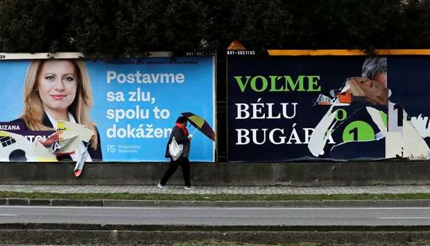 A woman walks past election posters in Bratislava