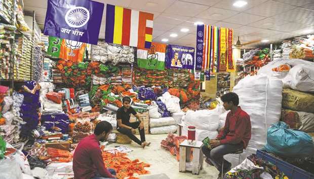 Shopkeepers display flags of various political parties in the old quarters of New Delhi yesterday.