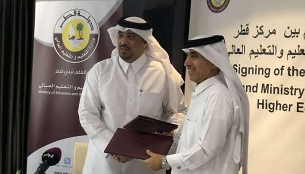 HE Undersecretary of the Ministry of Education and Higher Education, Dr Ibrahim bin Saleh al-Nuaimi, and Acting Managing Director at QLC, Dr Ali al-Kubaisi, exchange documents after signing the MoU.