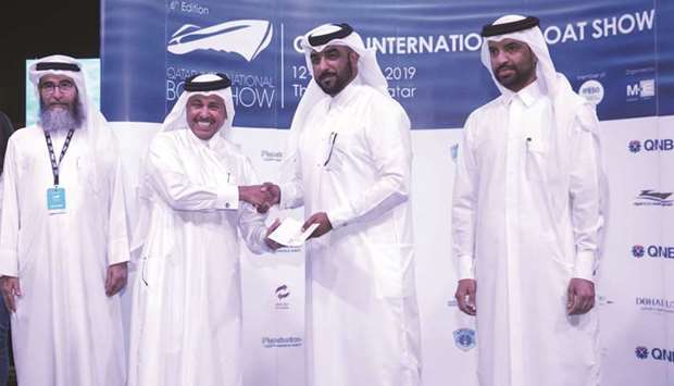 Rashid al-Madadi (second from left) presenting the keys of a Doha-manufactured boat to Lt Col Abdulaziz al-Mohannadi.