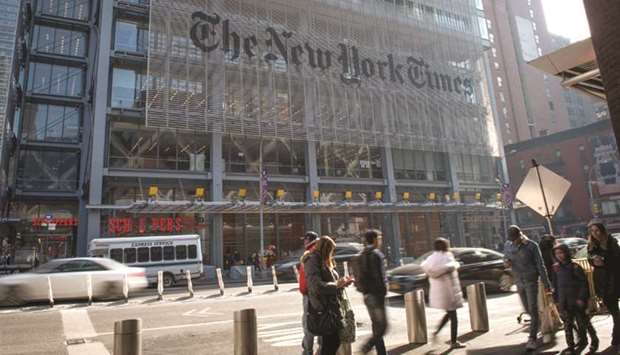 Pedestrians pass in front of the New York Times headquarters in New York, in this February 3, 2019 file photo. The Times is leveraging its digital success to invest more in journalism.