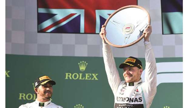 Mercedesu2019 Valtteri Bottas lifts the winneru2019s trophy as teammate Lewis Hamilton (left) looks on on the podium for the Formula 1 Australian Grand Prix at the Albert Park Grand Prix Circuit in Melbourne yesterday. (Reuters)