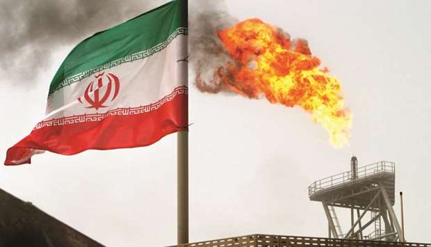 A gas flare on an oil production platform in the Soroush oil fields is seen alongside an Iranian flag (file). The Trump administration, for its part, says the aim is still to completely halt Iranu2019s oil shipments as it seeks to increase economic pressure on Tehran.