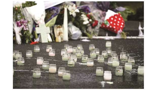 Lit candles are seen in front of floral tributes at a makeshift memorial for victims of mosque attacks, in Christchurch, New Zealand, yesterday.