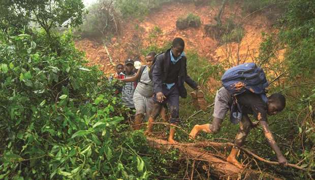 Students from St Charles Luanga school walk past a mudslide covering a major road at Skyline junction in Chimanimani, Manicaland Province, Zimbabwe.