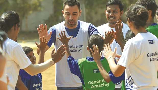 Former Spanish footballer Xavi Hernandez greets Indian children after a football game in Mumbai yesterday. A FIFA World Cup winner with Spain in 2010, Xavi is the global ambassador for the Generation Amazing programme of the Supreme Committee for Delivery and Legacy. (AFP)