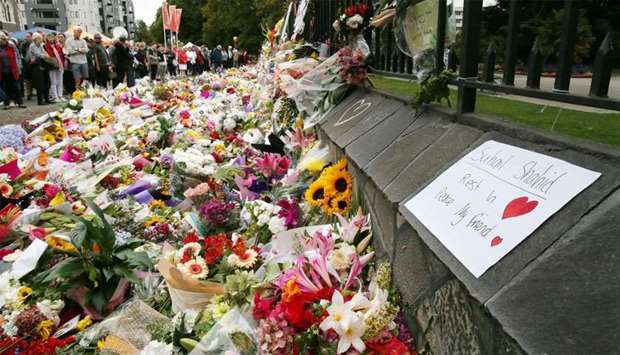 Residents look at flowers in tribute to victims in Christchurch