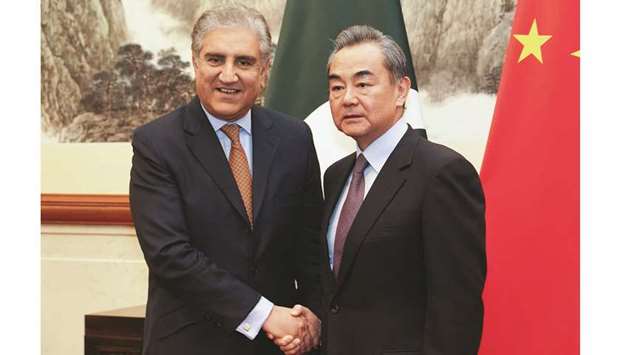 Chinese Foreign Minister Wang Yi and Pakistani Foreign Minister Shah Mehmood Qureshi shake hands during their meeting in Beijing yesterday.