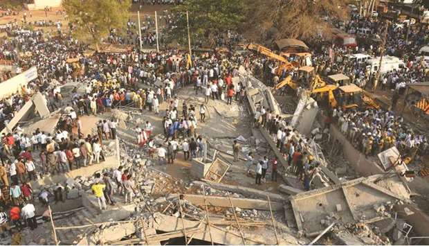 People gather near the rubble while rescue teams search for survivors after an under-construction building collapsed in Dharwad district of Karnataka yesterday.