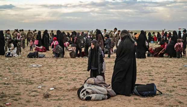 Civilians evacuated from the Islamic State (IS) group's embattled holdout of Baghouz wait at a screening area held by the US-backed Kurdish-led Syrian Democratic Forces (SDF), in the eastern Syrian province of Deir Ezzor
