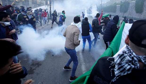 People clash with anti-riot police during a protest against President Abdelaziz Bouteflika's plan to extend his 20-year rule by seeking a fifth term in April elections in Algiers, Algeria