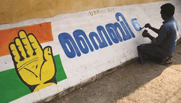 A man writes the name of a Congress party candidate for Ernakulam constituency on a roadside wall ahead of general election in Kochi yesterday.