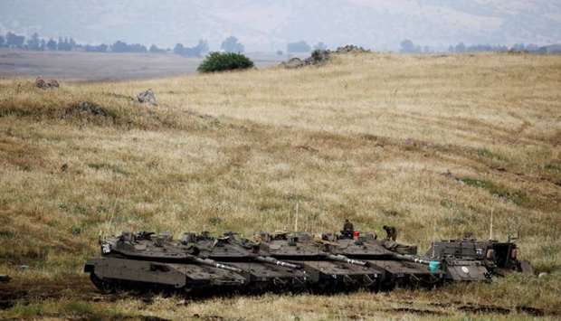 Israeli soldiers stand on tanks near the Israeli side of the border with Syria in the Israeli-occupied Golan Heights, Israel May 9, 2018.