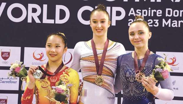 Winner Nina Derwael (centre) of Belgium poses on the podium for womenu2019s Uneven Bars event with second-placed Fan Yilin (left) of China and third-placed Anastasiia Iliankova of Russia in the Artistic Gymnastics Individual Apparatus World Cup yesterday. PICTURES: Thajudheen