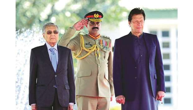 Malaysia Prime Minister Mahathir Mohamad and Pakistani Prime Minister Imran Khan stand during the national anthem at a ceremony in Islamabad.