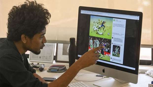 Bangladeshi architect Suhas Nahian, 29, gestures as he shows his painting on his computer at his office in Dhaka
