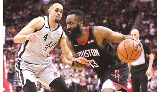 Houston Rockets guard James Harden (right) dribbles past San Antonio Spurs guard Derrick White during the NBA game in Houston on Friday. (USA TODAY Sports)