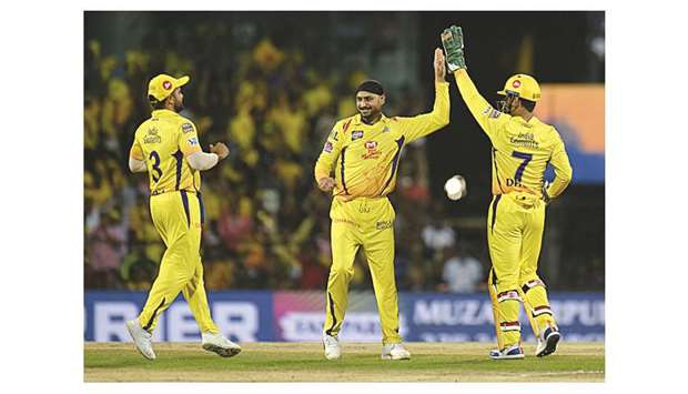 Chennai Super Kings cricketer Harbhajan Singh (centre) and Mahendra Singh Dhoni (right) celebrate the wicket of Royal Challengers Bangaloreu2019s Virat Kohli during the Indian Premier League match at the MA Chidhambaram Stadium in Chennai yesterday. (AFP)