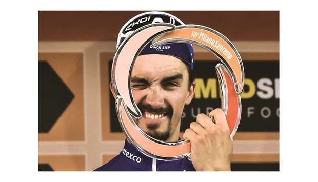 Franceu2019s Julian Alaphilippe poses with his trophy as he celebrates on the podium after winning the one-day classic cycling race Milan-San Remo yesterday. (AFP)
