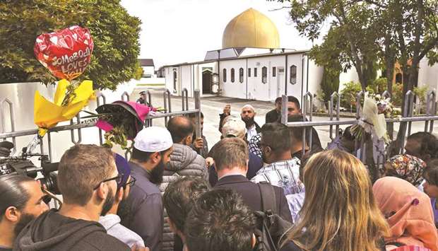 People including members of the local Muslim community queue at the gates of the Al Noor mosque after is was reopened in Christchurch yesterday.