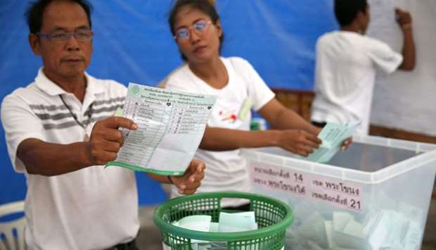 An electoral member shows a ballot during the vote counting, during the general election in Bangkok, Thailand