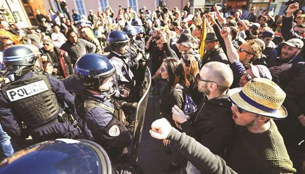 Protesters face police officers during an anti-government demonstration called by the u2018Yellow Vestu2019 movement in Nice yesterday.