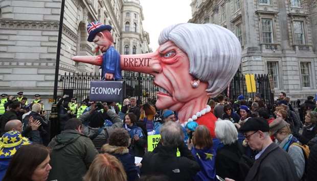 A puppet head of Britain's Prime Minister Theresa May spearing a representation of the British Economy is positioned on Whitehall outside Downing Street after a march and rally organised by the pro-European People's Vote campaign for a second EU referendum in central London. AFP