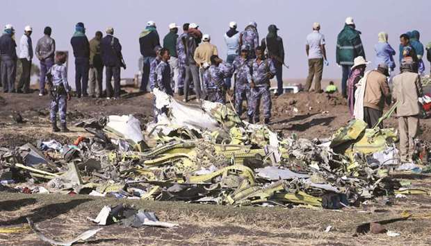 FILE PHOTO: Ethiopian Federal policemen stand at the scene of the Ethiopian Airlines Flight ET 302 plane crash, near the town of Bishoftu, southeast of Addis Ababa, Ethiopia, on March 11.