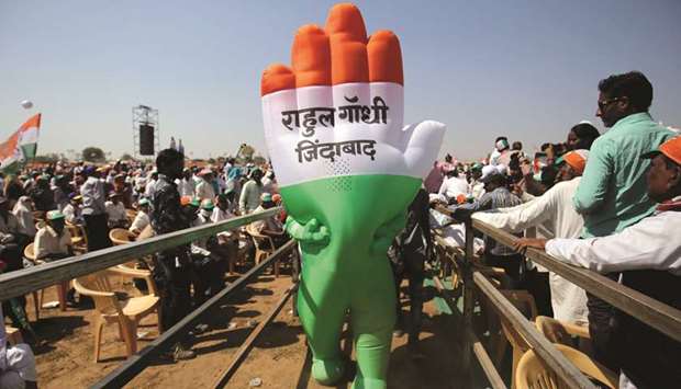 A supporter wearing an inflatable symbol of Congress Party walks during a public meeting in Gandhinagar, Gujarat. The words read: u201cLong live Rahul Gandhiu201d.