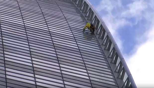 Television images showed Alain Robert climbing the the glass-fronted curved facade Engie headquarters building making use of the horizontal struts.