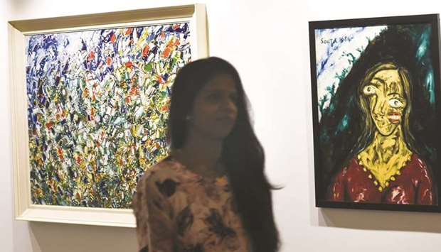 A staff member walks past Francis Newton Souzau2019s u201cCityscapeu201d (left) and u201cPortrait of Suruchi Chandu201d during a media preview at the Saffron Art Gallery in Mumbai yesterday, ahead of the Spring Live Auction being conducted by the gallery on behalf of the Income Tax Department. The tax authorities organised the auction to sell artwork that belonged to fugitive billionaire and jeweller Nirav Modi, who fled to London last year, after being involved in a massive bank fraud that rocked Indiau2019s corporate community.