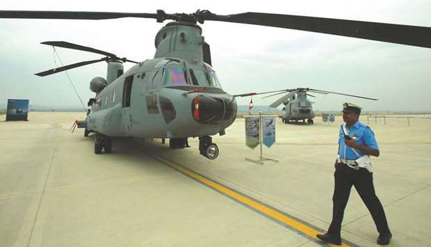 An Indian Air Force officer walks past CH-47F(I) Chinook helicopters during an induction ceremony at the Air Force Station in Chandigarh, yesterday.